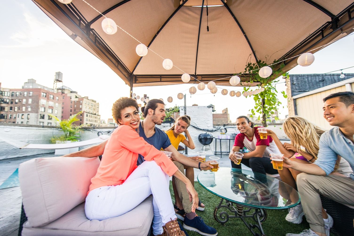 grupo de amigos tomando algo bajo el techo de una terraza